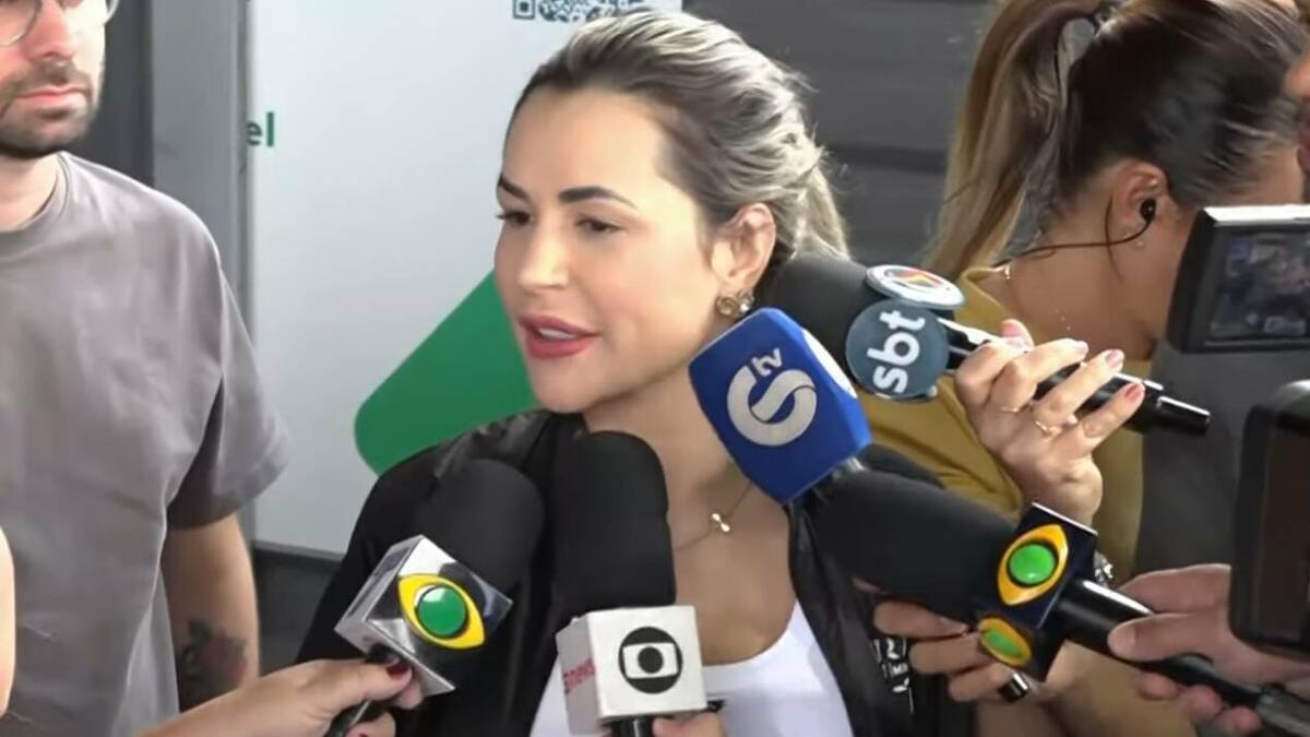 Deolane Bezerra rodeada de microfones de jornalistas