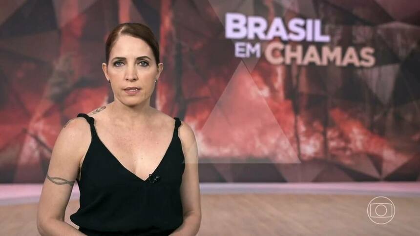 Poliana Abritta no cenário do Fantástico com o telão trazendo uma arte de queimadas e a chamada 'Brasil em Chamas'