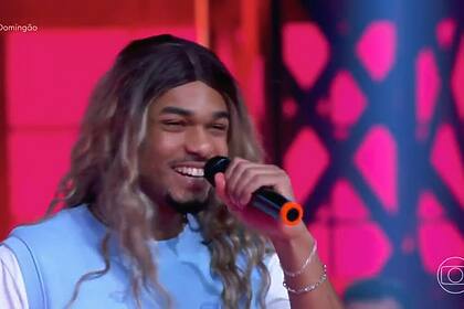 Juan Paiva vestido com a peruca loira de Joelha na Batalha do Lip Sync