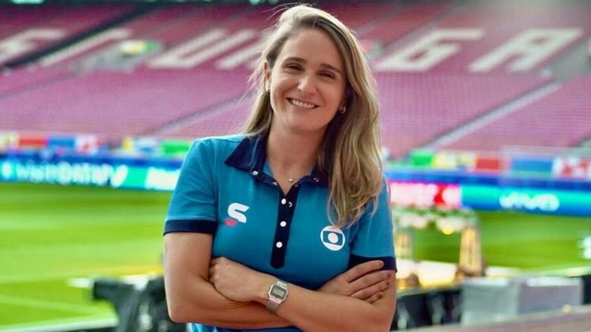 Julia Guimarães posando em um estádio de futebol com uniforme de esporte da Globo