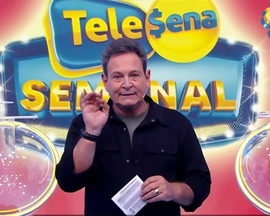 Luiz Ricardo no cenário da Tele Sena que está em luzes vermelhas