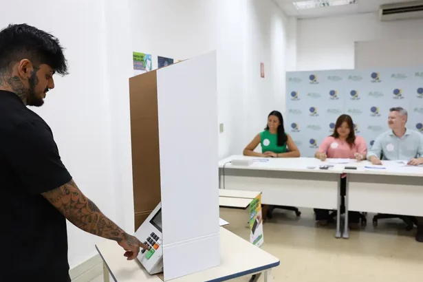 Homem na cabine de votação da Eleição 2024