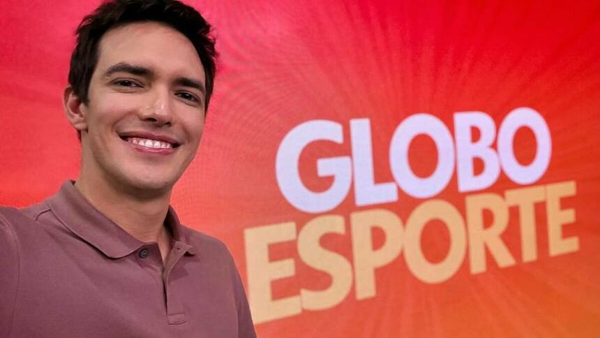 Alessandro Jodar posando em frente ao telão no cenário do Globo Esporte