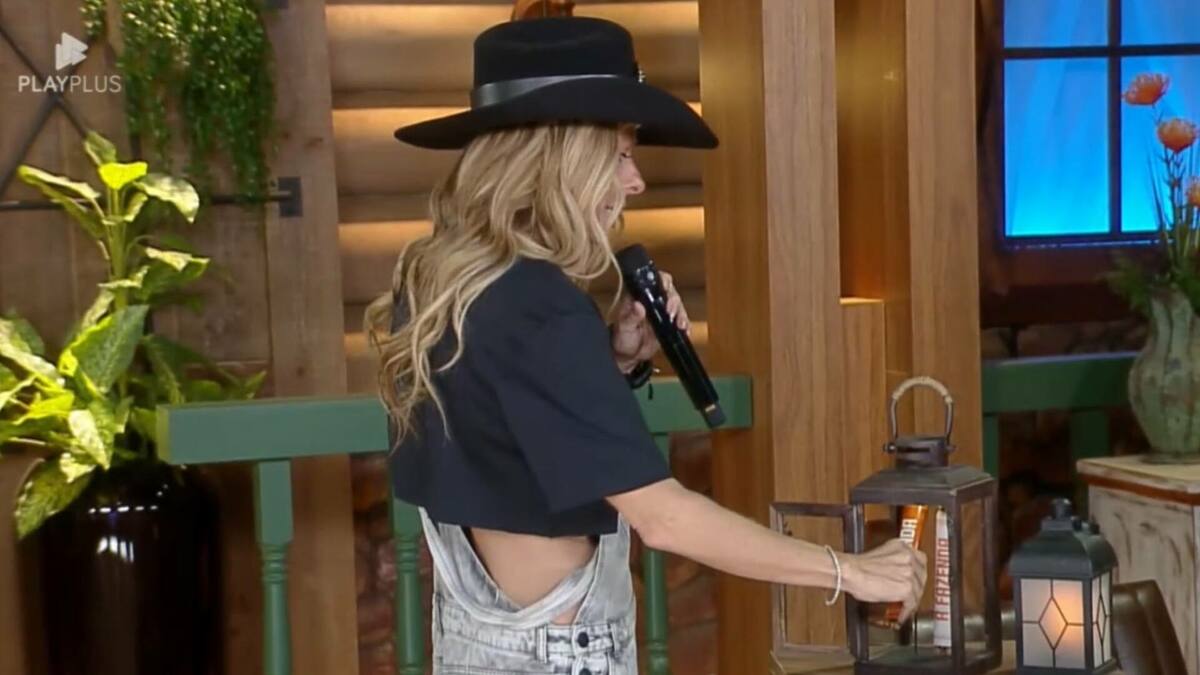 Adriane Galisteu colocando o Poder da Chama Laranja no lampião em A Fazenda