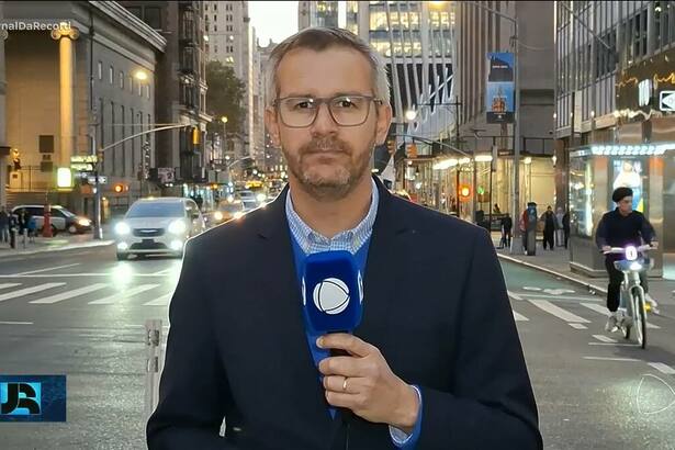 José Luiz Filho nas ruas de Nova York, Estados Unidos, segurando microfone do Jornal da RECORD