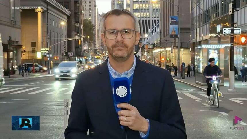 José Luiz Filho nas ruas de Nova York, Estados Unidos, segurando microfone do Jornal da RECORD