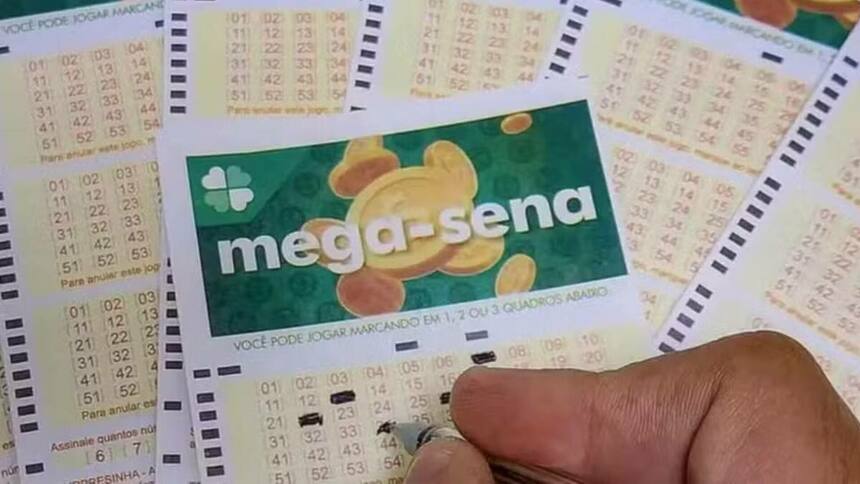 Uma mão preenchendo uma cartela de sorteio da Mega-Sena