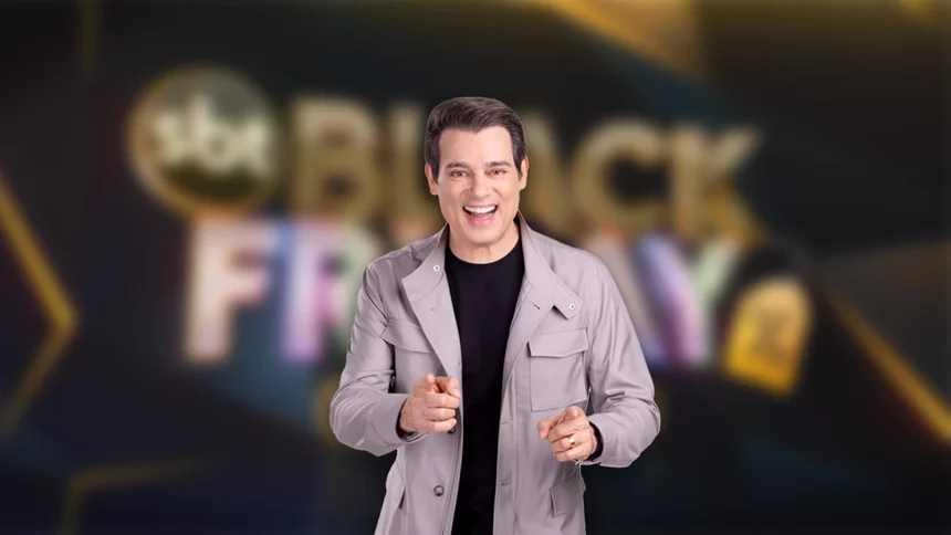 Celso Portiolli sorrindo na frente do logo SBT Black Friday