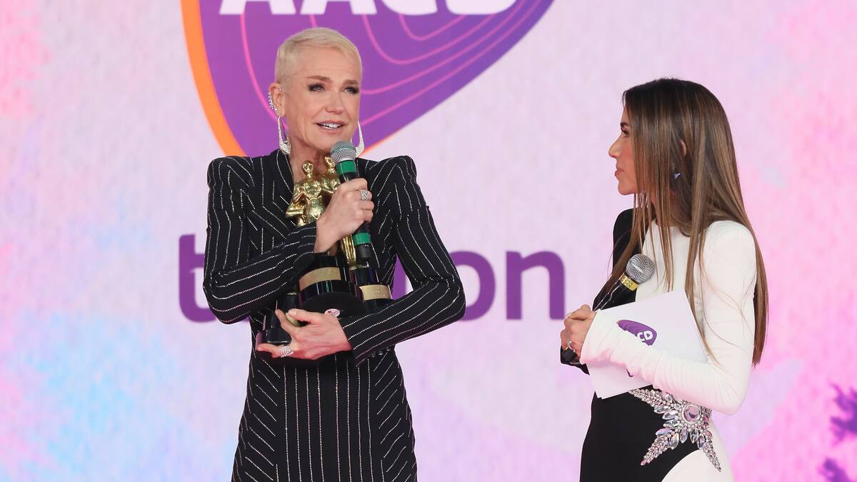 Xuxa segura os três prêmios do Troféu Imprensa no palco do Teleton 2024