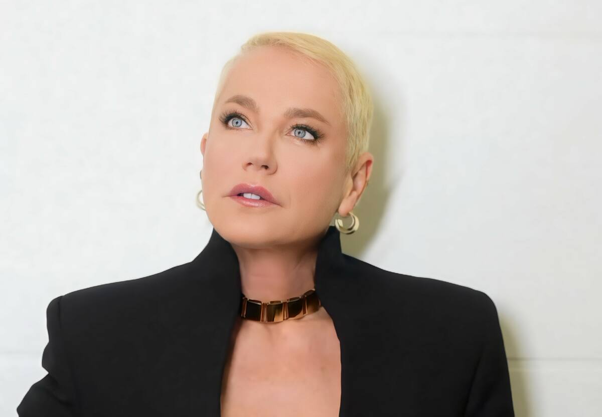 Xuxa com vestido preto olhando para cima