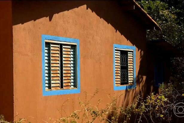 Parede de casa pintada com tinta à base de terra em reportagem do Globo Rural. As cores da casa são terrosas com detalhes azuis