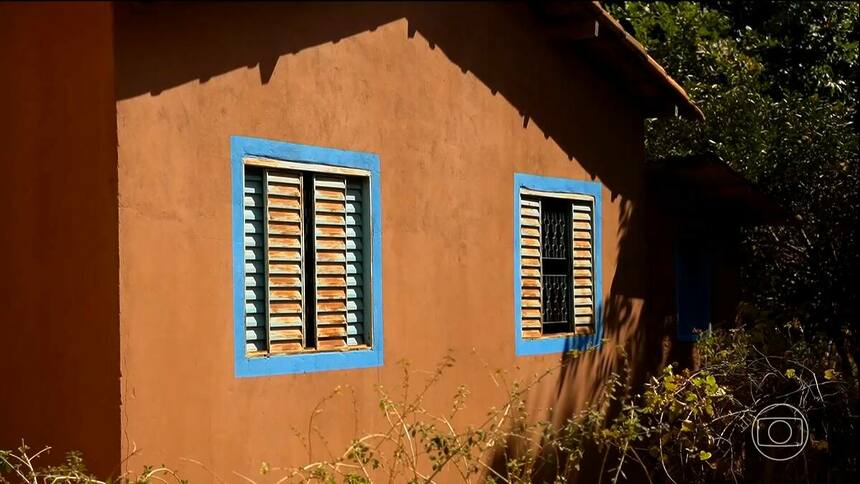 Parede de casa pintada com tinta à base de terra em reportagem do Globo Rural. As cores da casa são terrosas com detalhes azuis