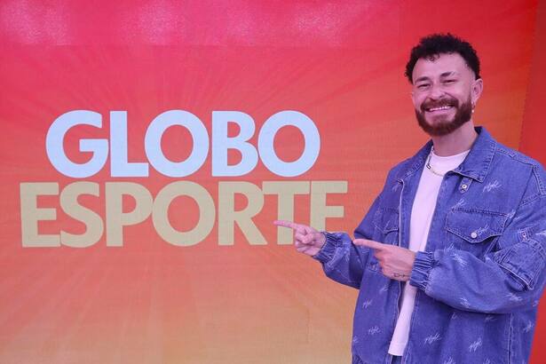 Fred Bruno aponta para o logo do Globo Esporte no cenário da TV Globo