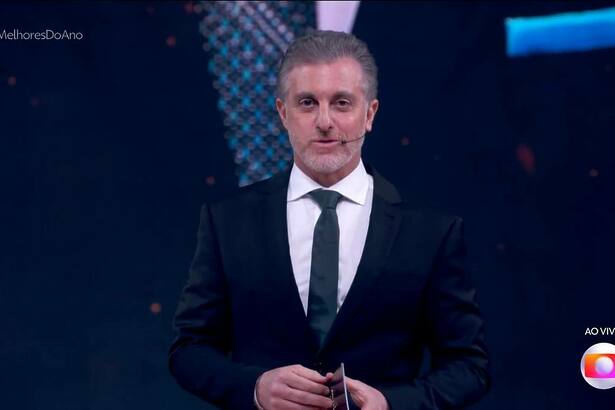 Luciano Huck, de terno e gravata, em trecho do Melhores do Ano