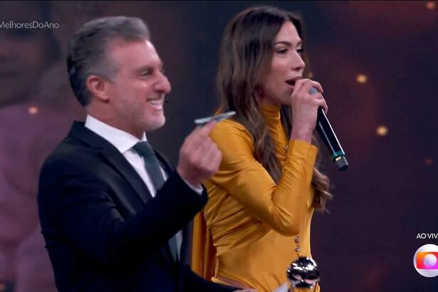 Luciano Huck e Patricia Abravanel jogando aviãozinho no cenário do Domingão