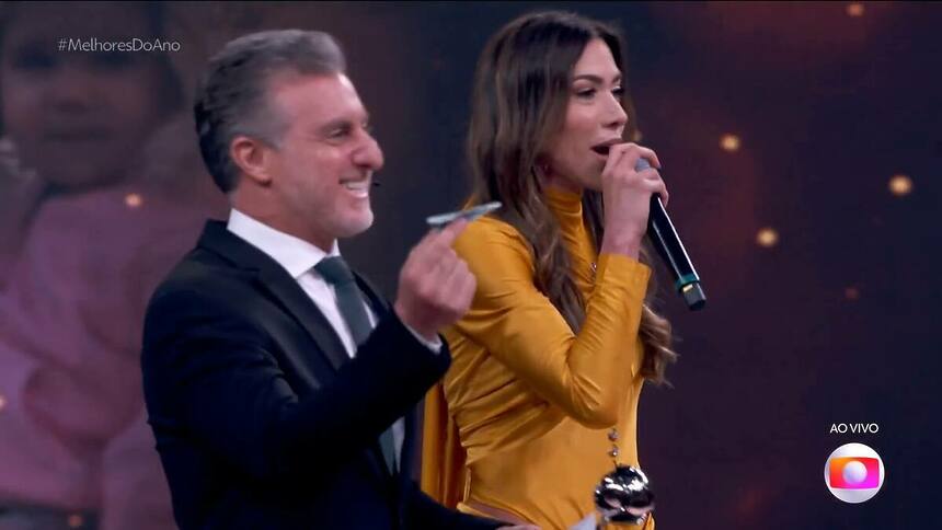 Luciano Huck e Patricia Abravanel jogando aviãozinho no cenário do Domingão