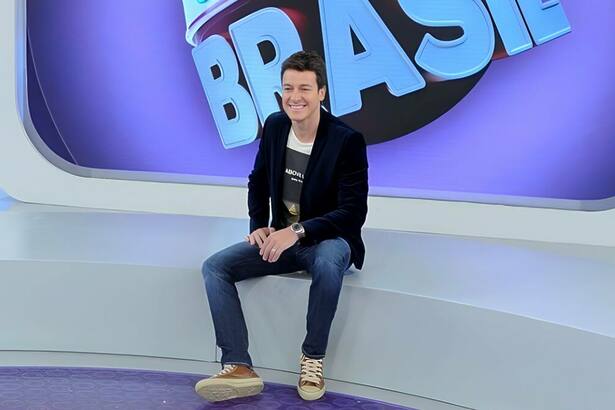 Rodrigo Faro sentado no palco do programa Melhor do Brasil, da RECORD. Ele está sorrindo