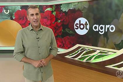 Sandro Ivanowski em frente ao logo do SBT Agro no estúdio da emissora