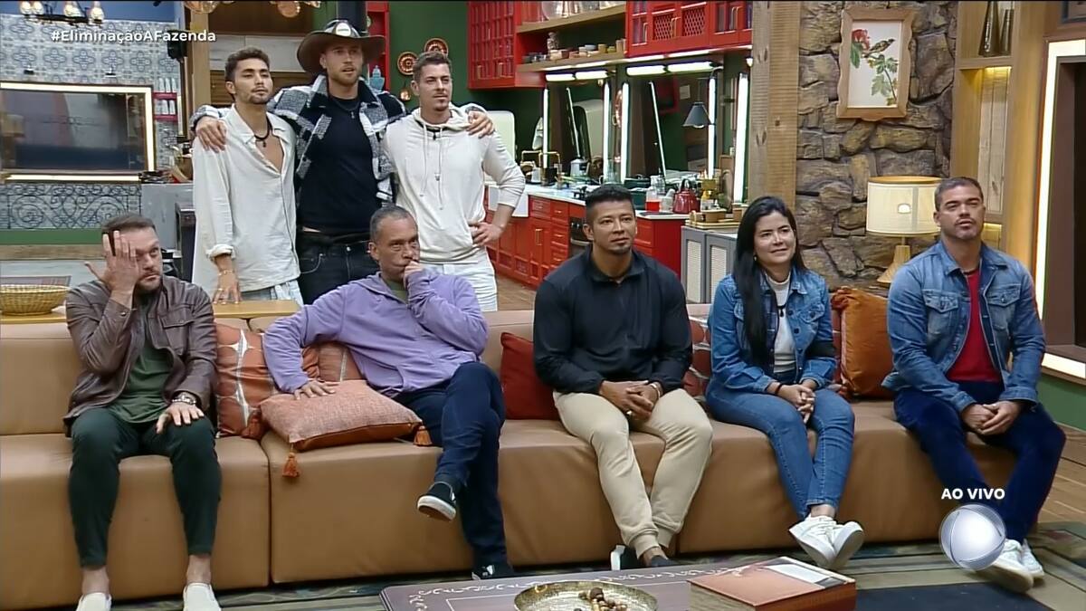 Top 8 de A Fazenda na sala da sede. Em pé atrás do sofá estão: Gui, Yuri e Sacha abraçados. Sentados no sofá estão: Albert, Juninho, Gilsão, Vanessa e Sidney Sampaio
