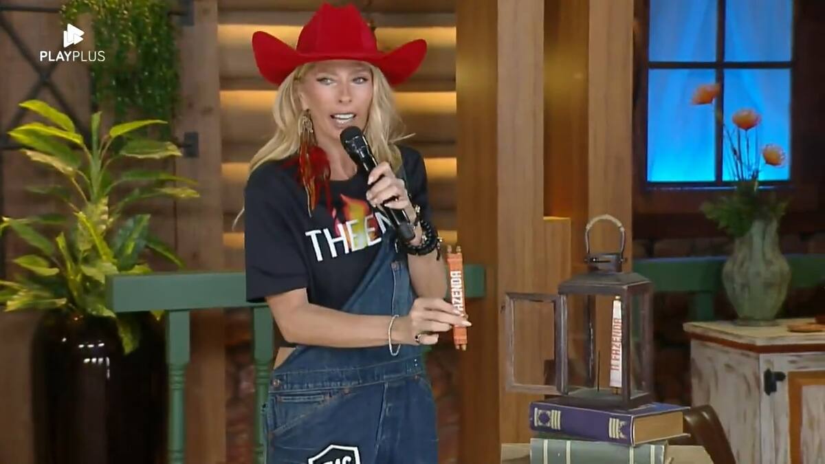 Adriane Galisteu de chapéu vermelho colocando o poder laranja no Lampião antes da Prova de Fogo