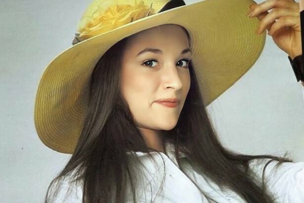 Olivia Hussey segura chapéu amarelo na cabeça e sorrir