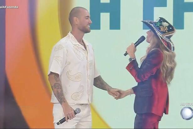 Adriane Galisteu segura nas mãos de Yuri Bonotto no palco da Final de A Fazenda 16