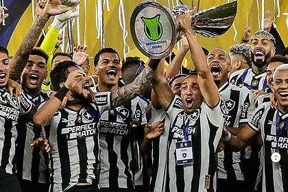 Jogadores do Botafogo erguendo a taça de campeão do Brasileirão 2024