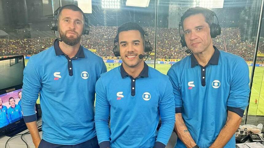 Dênis Medeiros e os comentaristas Cabral Neto e Danny Morais posando com o uniforme da Globo