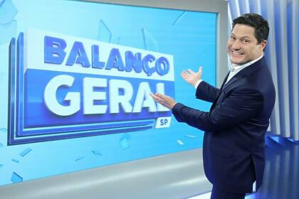 Eleandro Passaia apontando pro telão no estúdio do Balanço Geral