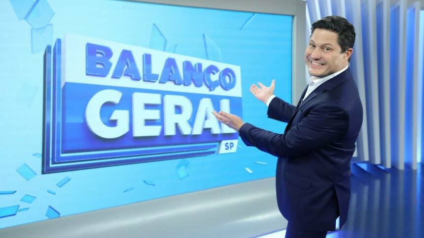 Eleandro Passaia apontando pro telão no estúdio do Balanço Geral