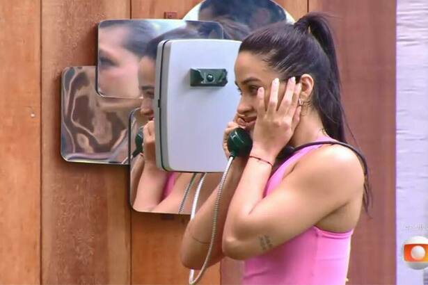 Eva, com a mão no ouvido, ao atender o Big Fone no BBB 25