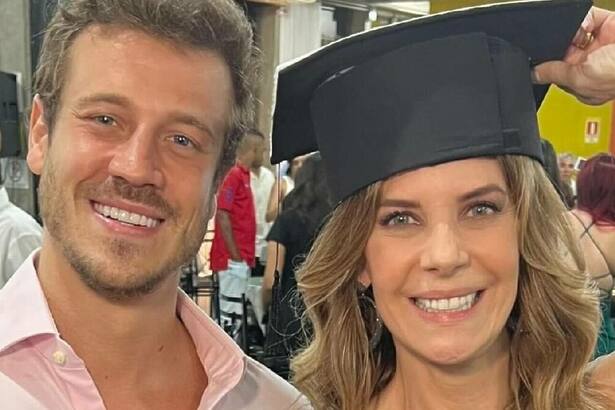 Fabiana Scaranzi, de beca na colação de grau, em foto posada ao lado do filho