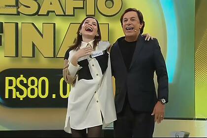 Giselle Batista sorrindo e comemorando vitória no Acerte ou Caia! ao lado de Tom Cavalcante