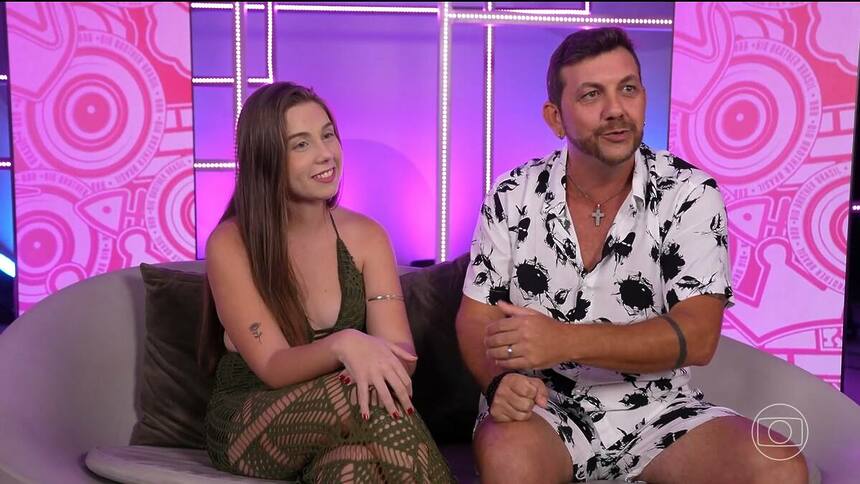 Edilberto e Raissa sentados em um sofá na apresentação do Big Day do BBB 25