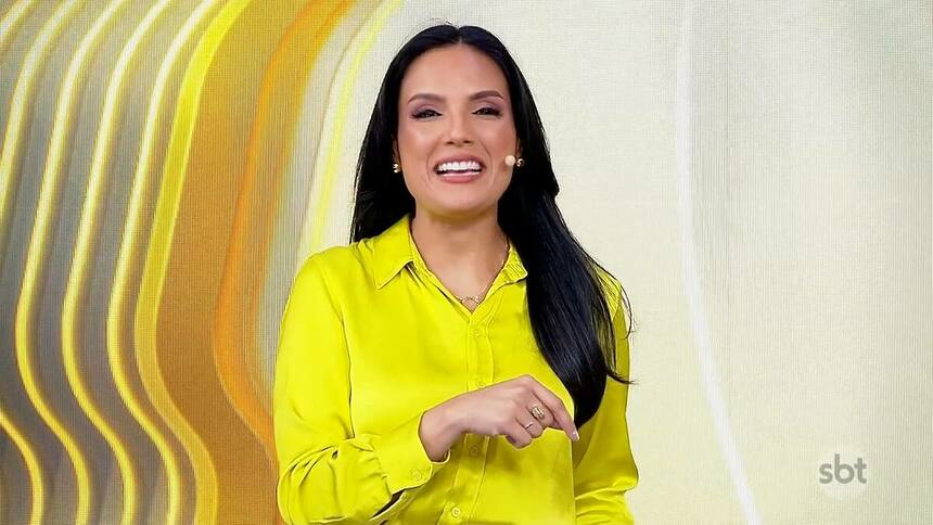 Marcia Dantas veste amarelo e sorri no cenário do Primeiro Impacto