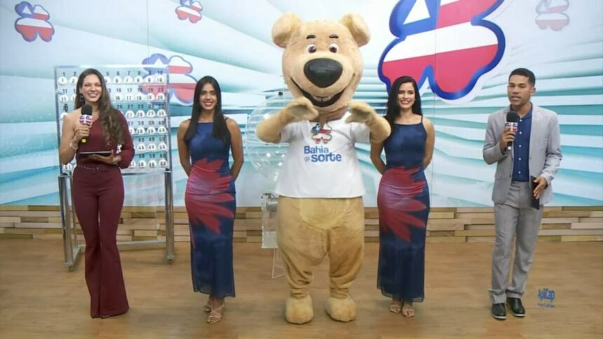 Luck, o mascote de pelúcia do Bahia dá Sorte, ao lado dos apresentadores no centro do palco