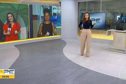 Clarissa Góes de blusa azul e calça nude andando pelo cenário do Bom Dia PE