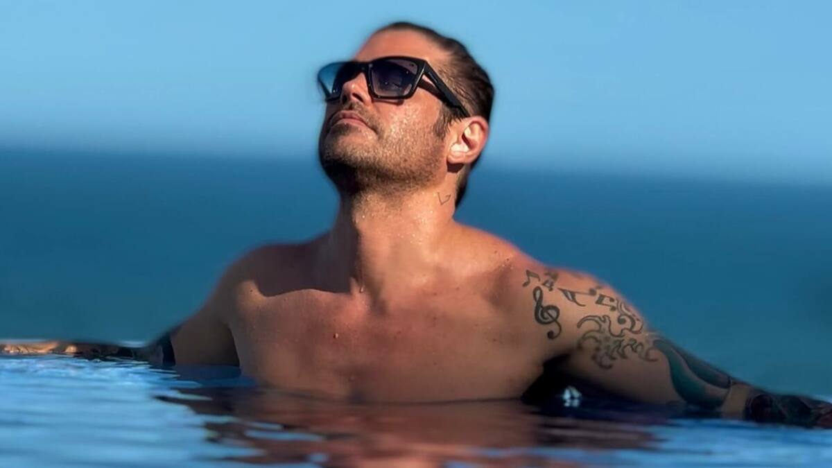 Dado Dolabella, de óculos escuro, dentro de uma piscina