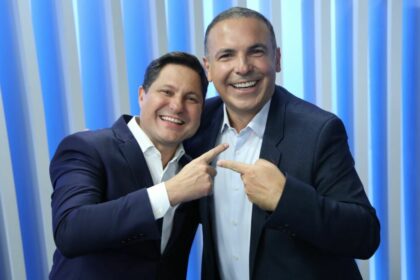 Eleandro Passaia e Reinaldo Gottino abraçados e sorridentes no RECORD