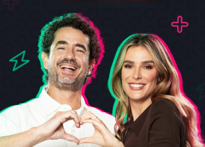 Felipe Andreoli e Rafa Brites fazem coração com a mão e sorriem em foto promocional do Power Couple Brasil 7 na RECORD