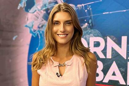 Joana Treptow em pé no cenário do Jornal da Band