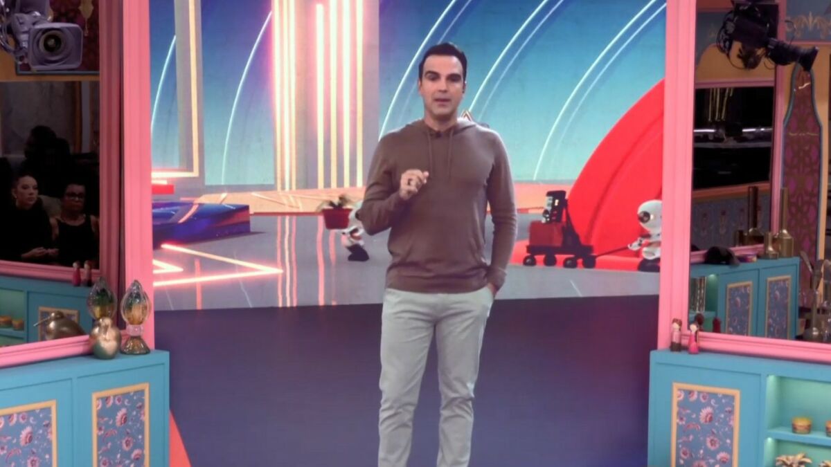 Tadeu Schmidt falando pelo telão da sala no BBB 25
