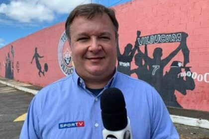 Thiago Mastroianni em foto posada com o uniforme de esportes da Globo, segundo um microfone.