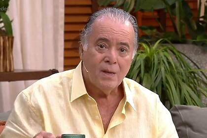 Tony Ramos, sentado no sofá do É de Casa, com um caneca de café na mão