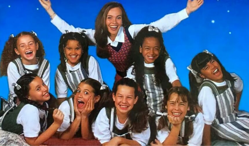 Elenco principal da novela Chiquititas edição de 1997 todas sorridentes em um fundo azul