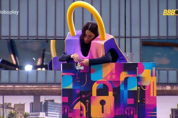 Eva exausta colocando a chave no cadeado do castigo do Monstro do BBB 25