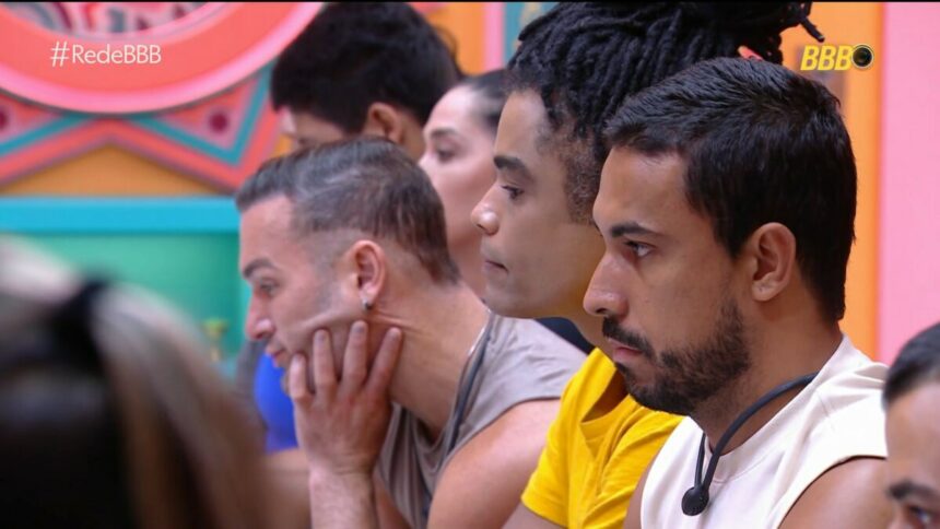 Diego, que já está emparedado, Diogo e Maike sentados no sofá da sala ao lado dos demais moradores do BBB 25