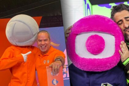 Fred Linhares ao lado do mascote da RECORD com o logo cinza e roupa laranja dividindo tela com MArcos Mion abraçado ao Globolinho, mascote da Globo