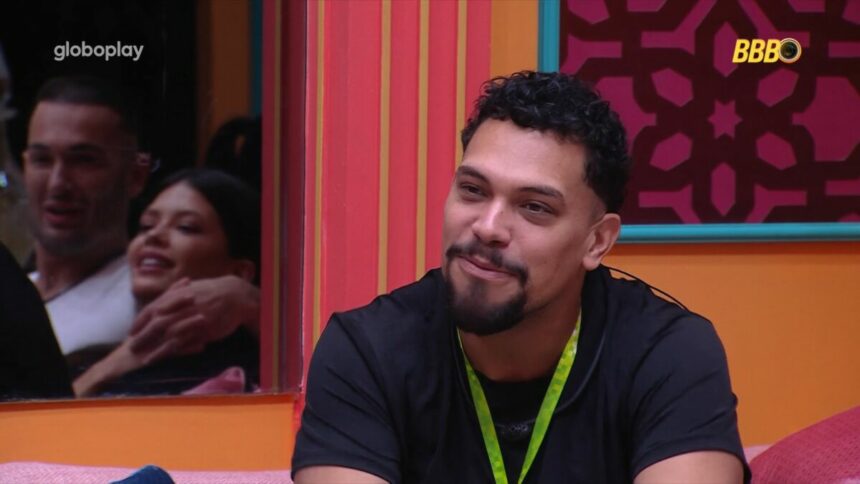 Vinicius sorridente na sala do BBB 25 aguardando a Prova do Líder