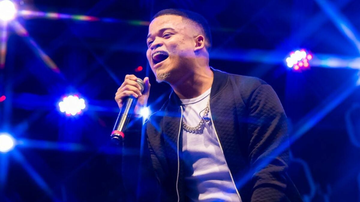 Cantor Rafa Diniz se apresentando em um show com luzes